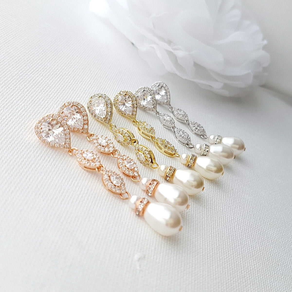 Abby crystal and teardrop pearl earrings in rose gold, gold and silver finishes arranged side by side.