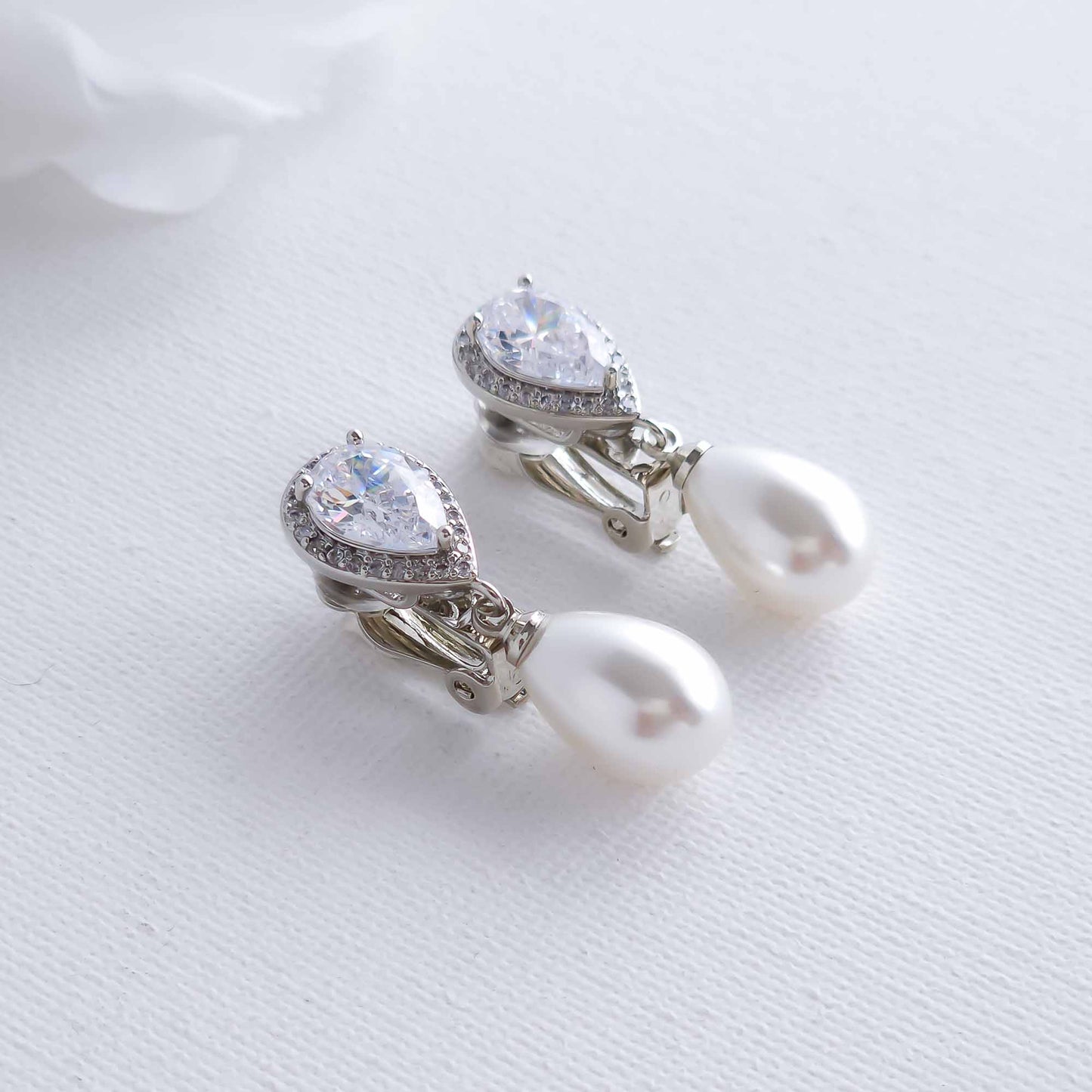 Pearl and crystal clip on earrings on a white background