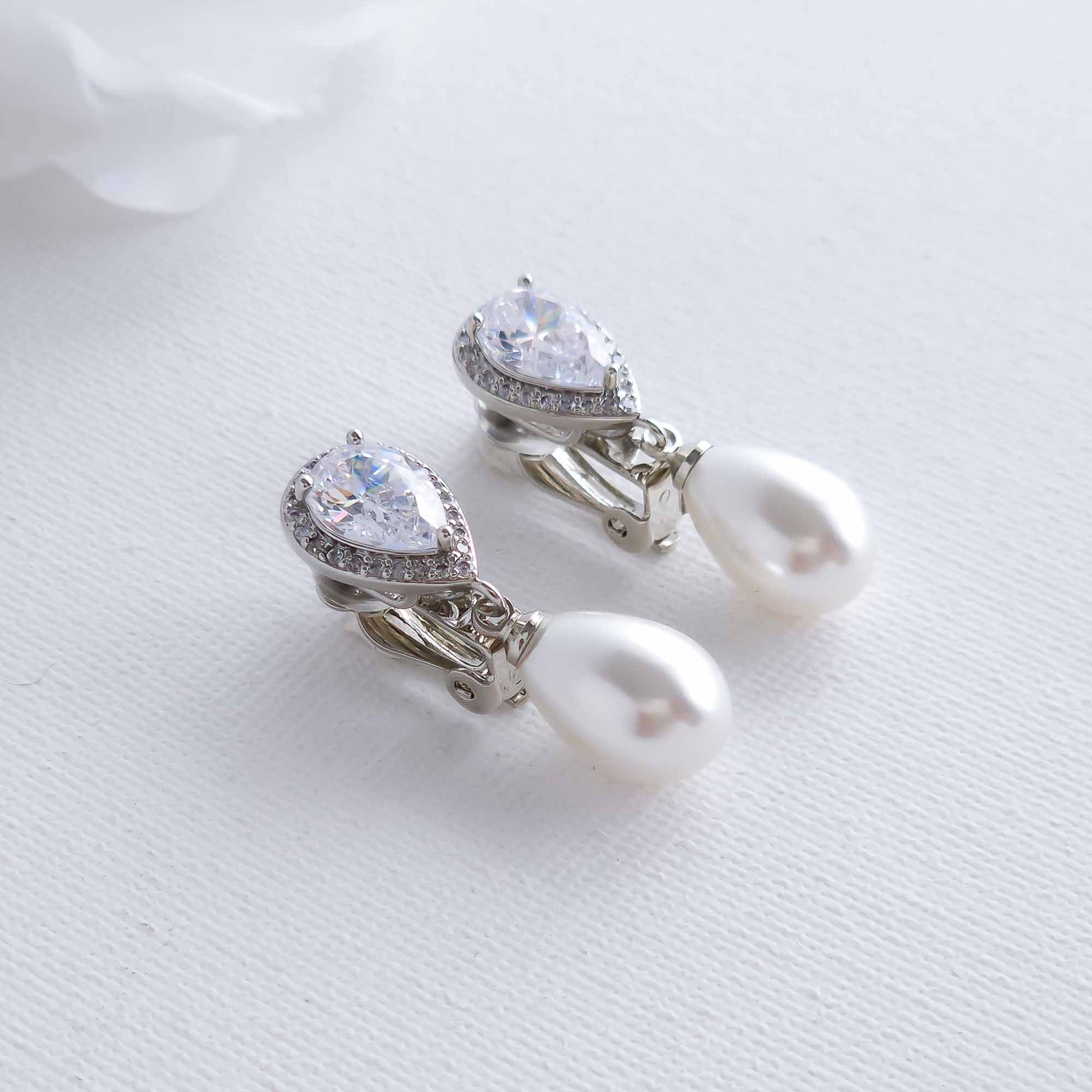Pearl and crystal clip on earrings on a white background