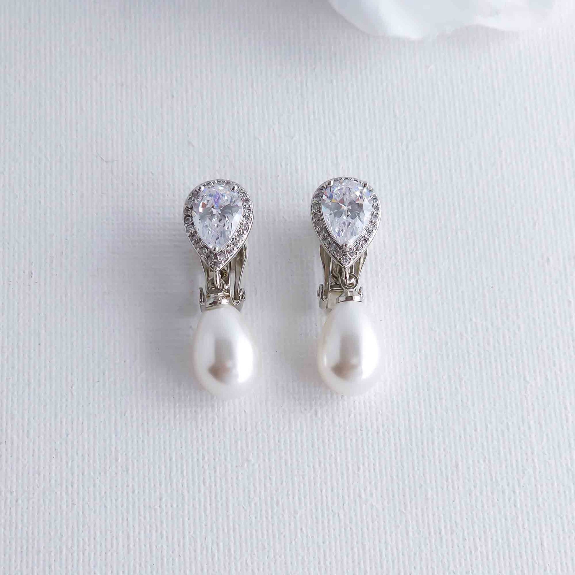 clip on Pearl and crystal teardrop earrings on a light gray background