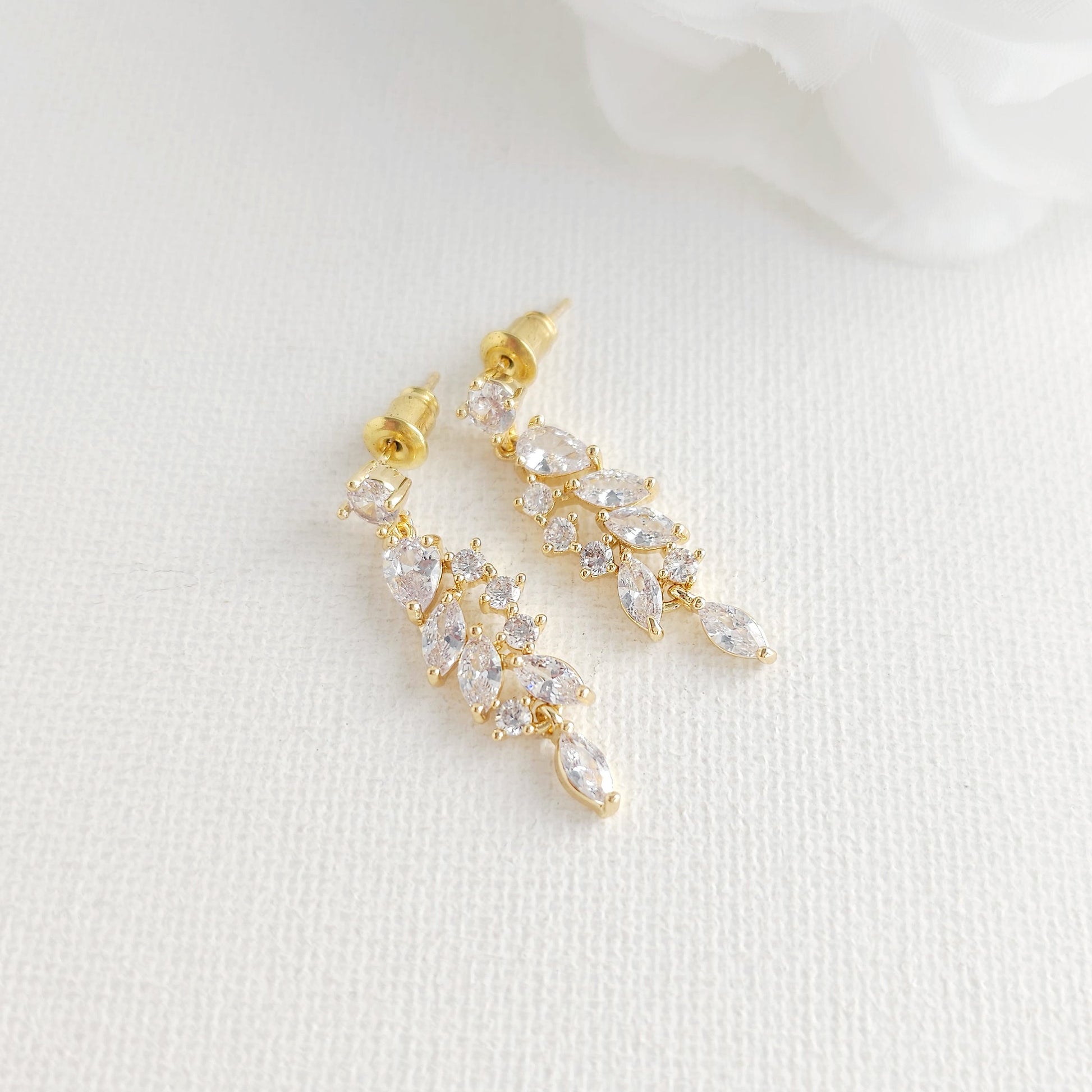A pair of gold leaf-shaped drop earrings adorned with clear marquise and round CZ crystals